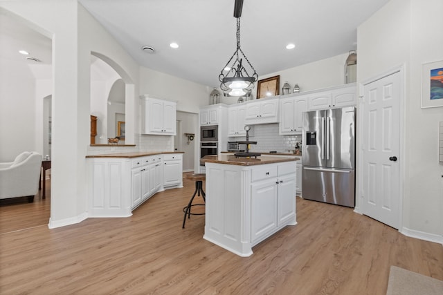 8228 Shady Valley Dr, Benbrook, TX 76116 - kitchen with appliances with stainless steel finishes, decorative backsplash, a kitchen island, white cabinets, and recessed lighting