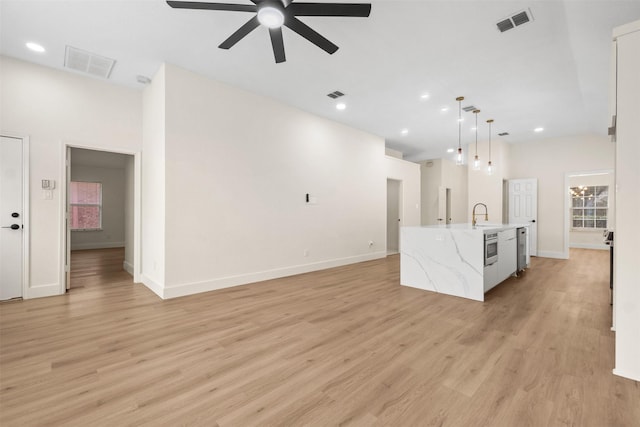 5809 Hidden Pine Ln, Mckinney, TX 75070 - unfurnished living room featuring a ceiling fan, light wood-style flooring, recessed lighting, baseboards, and a sink