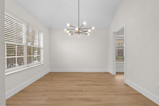5809 Hidden Pine Ln, Mckinney, TX 75070 - unfurnished room with a chandelier, vaulted ceiling, light wood-type flooring, and baseboards