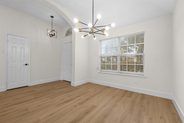 5809 Hidden Pine Ln, Mckinney, TX 75070 - unfurnished dining area with a chandelier, light wood-style flooring, arched walkways, and baseboards