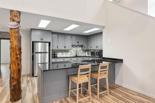 1327 Whispering Springs Dr, Tool, TX 75143 - kitchen with stainless steel appliances, dark countertops, tasteful backsplash, baseboards, and light wood finished floors