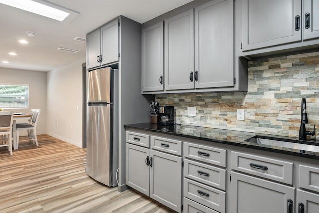 1327 Whispering Springs Dr, Tool, TX 75143 - kitchen featuring freestanding refrigerator, gray cabinets, a sink, decorative backsplash, and light wood-type flooring