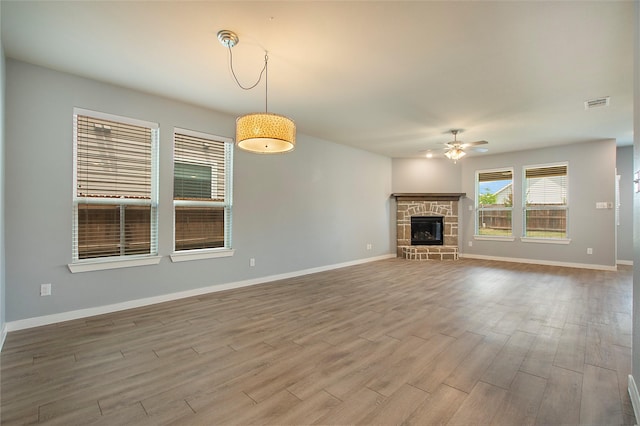 2151 Slow Stream Dr, Royse City, TX 75189 - unfurnished living room with a ceiling fan, wood finished floors, baseboards, and a stone fireplace
