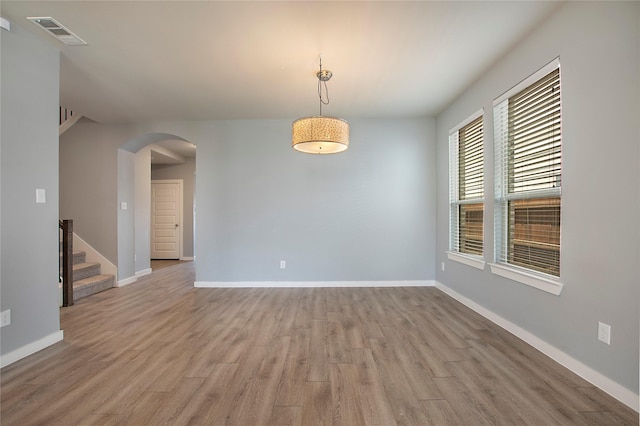 2151 Slow Stream Dr, Royse City, TX 75189 - empty room with arched walkways, wood finished floors, baseboards, and stairway