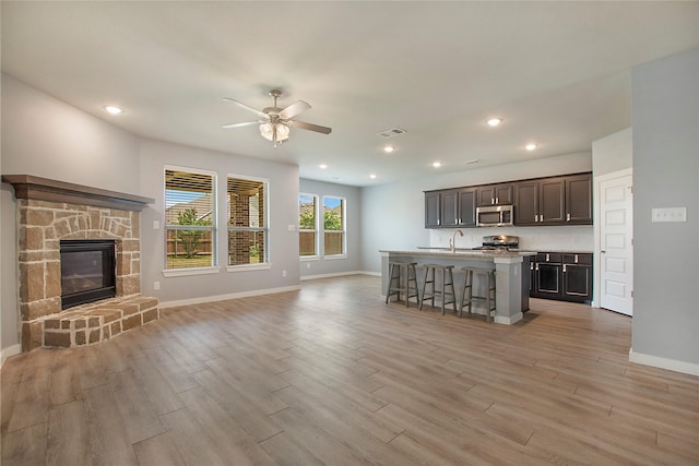 2151 Slow Stream Dr, Royse City, TX 75189 - kitchen with stainless steel appliances, open floor plan, a kitchen bar, light wood-type flooring, and recessed lighting