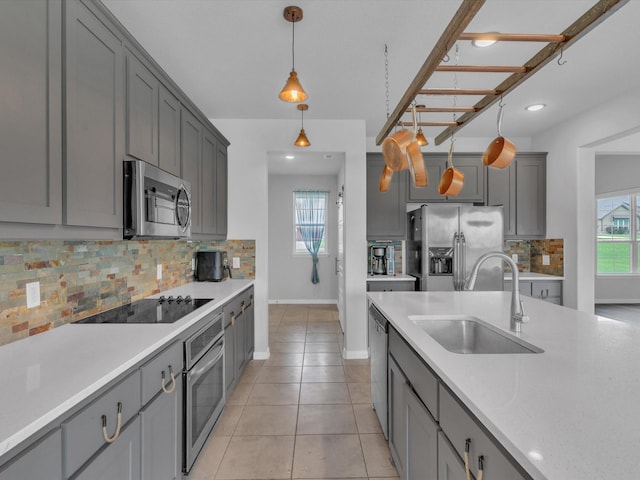 1013 Northern Oaks Ct, Springtown, TX 76082 - kitchen featuring appliances with stainless steel finishes, a sink, gray cabinetry, baseboards, and light countertops