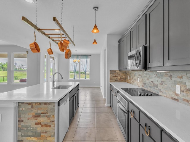 1013 Northern Oaks Ct, Springtown, TX 76082 - kitchen with stainless steel appliances, a sink, tasteful backsplash, an island with sink, and light countertops