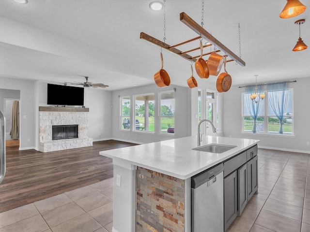 1013 Northern Oaks Ct, Springtown, TX 76082 - kitchen featuring stainless steel dishwasher, a sink, light tile patterned floors, a ceiling fan, and light countertops