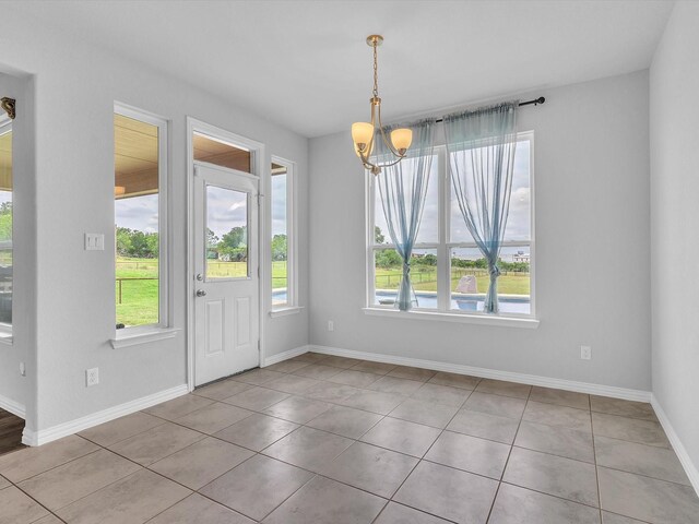1013 Northern Oaks Ct, Springtown, TX 76082 - unfurnished dining area with plenty of natural light, a chandelier, tile patterned flooring, and baseboards