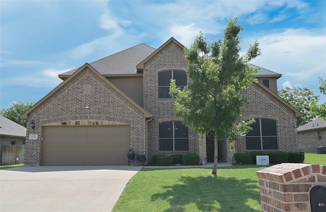 606 Brandt St, Grandview, TX 76050 - french provincial home with brick siding, a garage, driveway, and a front lawn