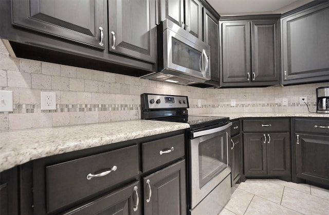 606 Brandt St, Grandview, TX 76050 - kitchen featuring stainless steel appliances, backsplash, light tile patterned floors, and light stone counters