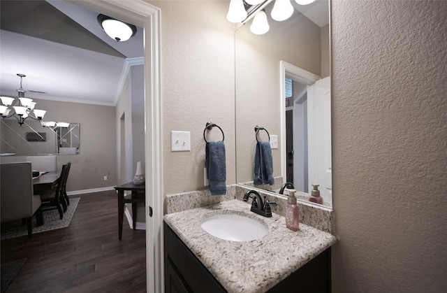 606 Brandt St, Grandview, TX 76050 - bathroom with crown molding, a chandelier, wood finished floors, vanity, and a textured wall