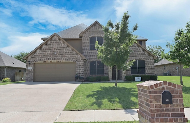 606 Brandt St, Grandview, TX 76050 - french provincial home with a garage, brick siding, concrete driveway, a front yard, and central AC unit