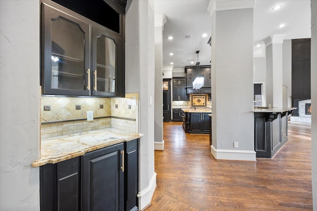 1229 Manchester Dr, Mclendon Chisholm, TX 75032 - kitchen with dark wood-style flooring, glass insert cabinets, decorative backsplash, ornamental molding, and baseboards
