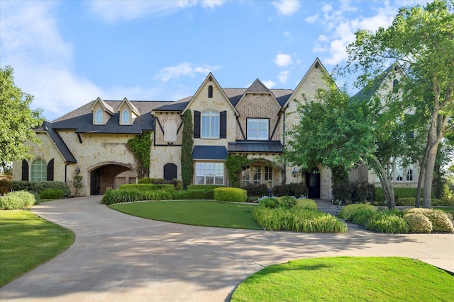 1229 Manchester Dr, Mclendon Chisholm, TX 75032 - french country home featuring stone siding, a front yard, curved driveway, and a standing seam roof