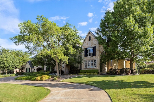 1229 Manchester Dr, Mclendon Chisholm, TX 75032 - tudor-style house with stone siding, a front lawn, and curved driveway