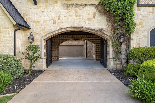 1229 Manchester Dr, Mclendon Chisholm, TX 75032 - view of exterior entry with stone siding, driveway, and a garage