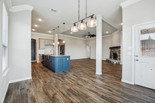 13609 Summer Moon Trl, Ponder, TX 76259 - kitchen featuring ceiling fan, blue cabinetry, open floor plan, arched walkways, and a stone fireplace