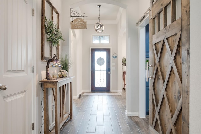 13609 Summer Moon Trl, Ponder, TX 76259 - foyer entrance featuring a barn door, baseboards, arched walkways, and ornamental molding