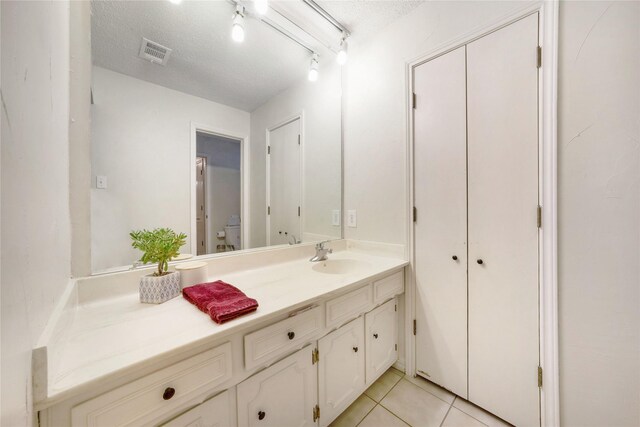 1715 Venetian Cir, Arlington, TX 76013 - bathroom with vanity, toilet, a textured ceiling, and tile patterned floors