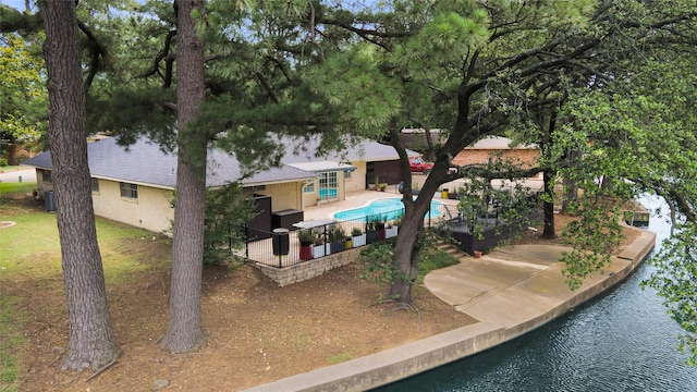 1715 Venetian Cir, Arlington, TX 76013 - rear view of house with a water view, a patio area, an outdoor pool, a shingled roof, and central air condition unit