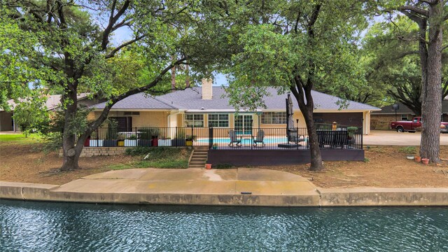 1715 Venetian Cir, Arlington, TX 76013 - rear view of property featuring an outdoor pool, a chimney, a water view, and a patio area