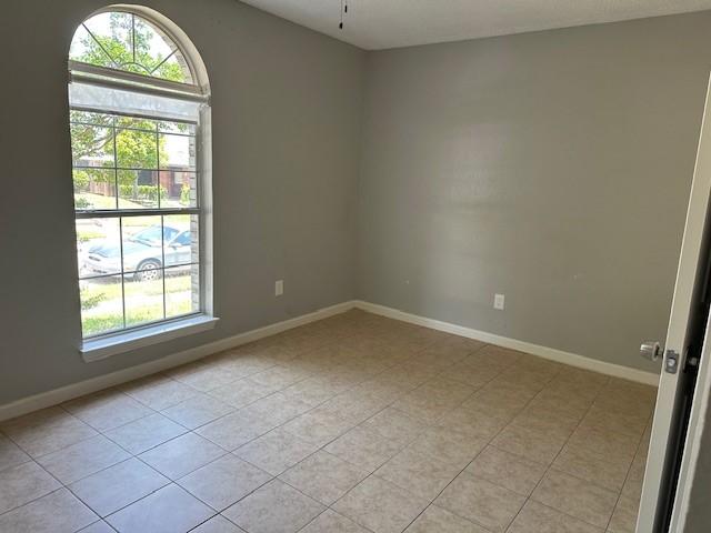 1042 Kim Ln, Mesquite, TX 75149 - empty room with light tile patterned floors, baseboards, and ceiling fan