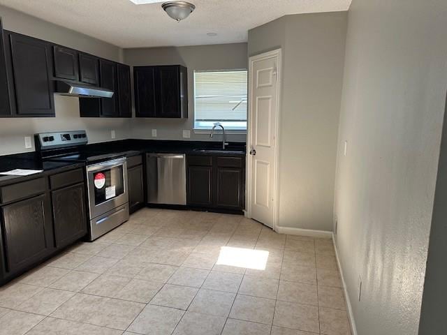 1042 Kim Ln, Mesquite, TX 75149 - kitchen featuring stainless steel appliances, a sink, dark countertops, and under cabinet range hood