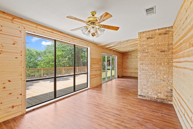 791 Cedar Oak Dr, Pottsboro, TX 75076 - spare room featuring wooden walls, wood finished floors, ceiling fan, and lofted ceiling