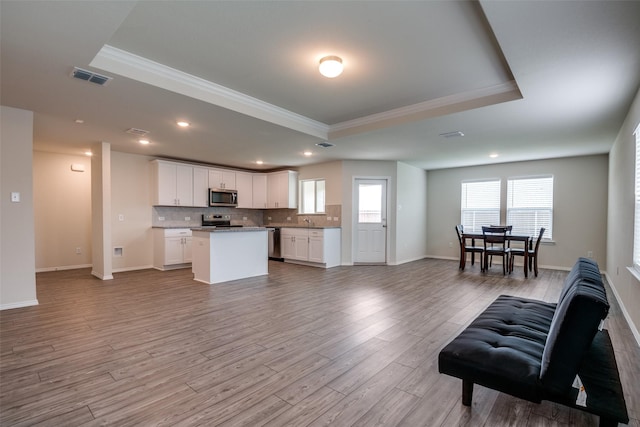 1609 Silas Dr, Forney, TX 75126 - living room with a tray ceiling, ornamental molding, light wood-type flooring, recessed lighting, and baseboards