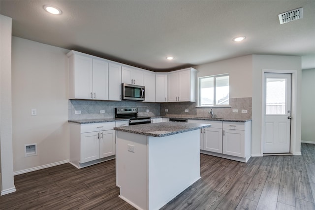 1609 Silas Dr, Forney, TX 75126 - kitchen with appliances with stainless steel finishes, a sink, dark wood finished floors, tasteful backsplash, and recessed lighting