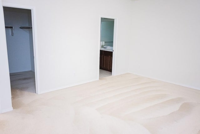 2225 Bernese Ln, Fort Worth, TX 76131 - unfurnished bedroom with a walk in closet, light carpet, a closet, ensuite bath, and baseboards