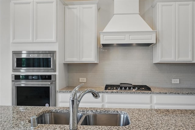 517 Fenwick Dr, Sunnyvale, TX 75182 - kitchen with stainless steel appliances, premium range hood, a sink, and white cabinetry