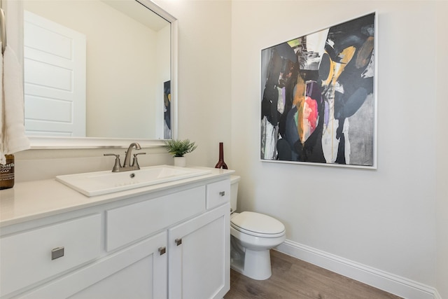 2233 Fort Bliss, Mesquite, TX 75149 - bathroom featuring wood finished floors, vanity, baseboards, and toilet