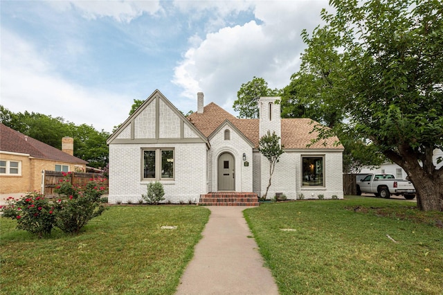 1225 Sayles Blvd, Abilene, TX 79605 - english style home featuring brick siding, a chimney, and a shingled roof