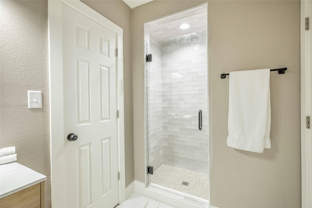 1225 Sayles Blvd, Abilene, TX 79605 - bathroom with a stall shower, vanity, and baseboards