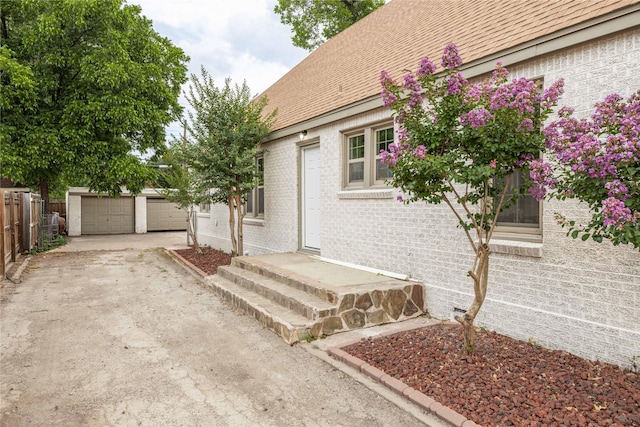 1225 Sayles Blvd, Abilene, TX 79605 - property entrance featuring brick siding, a garage, driveway, and roof with shingles