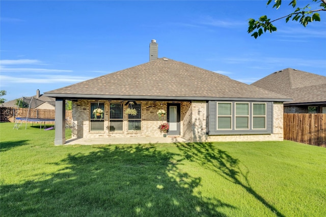 1621 Whispering Trail Dr, Waxahachie, TX 75165 - back of property with a trampoline, brick siding, a patio, roof with shingles, and a chimney