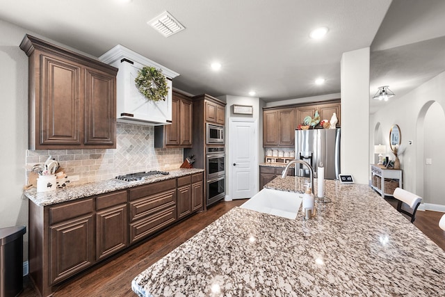 4705 Stillhouse Hollow Ln, Argyle, TX 76226 - kitchen with appliances with stainless steel finishes, a sink, arched walkways, dark wood-style flooring, and recessed lighting