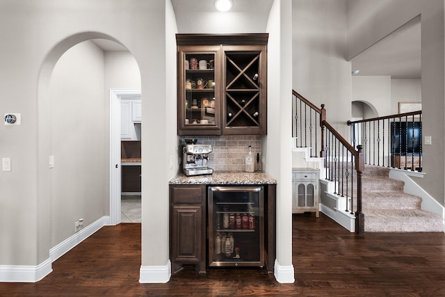 4705 Stillhouse Hollow Ln, Argyle, TX 76226 - bar area with beverage cooler, arched walkways, dark wood-style flooring, and stairs