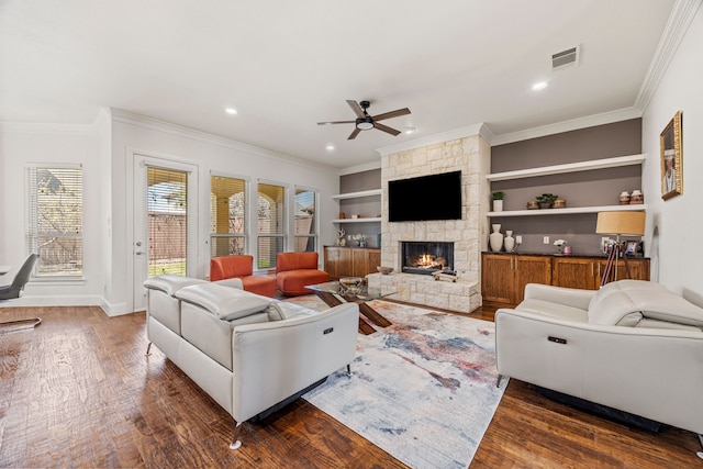 3413 De Vinci Dr, Plano, TX 75074 - living area with a ceiling fan, dark wood-type flooring, crown molding, a stone fireplace, and recessed lighting