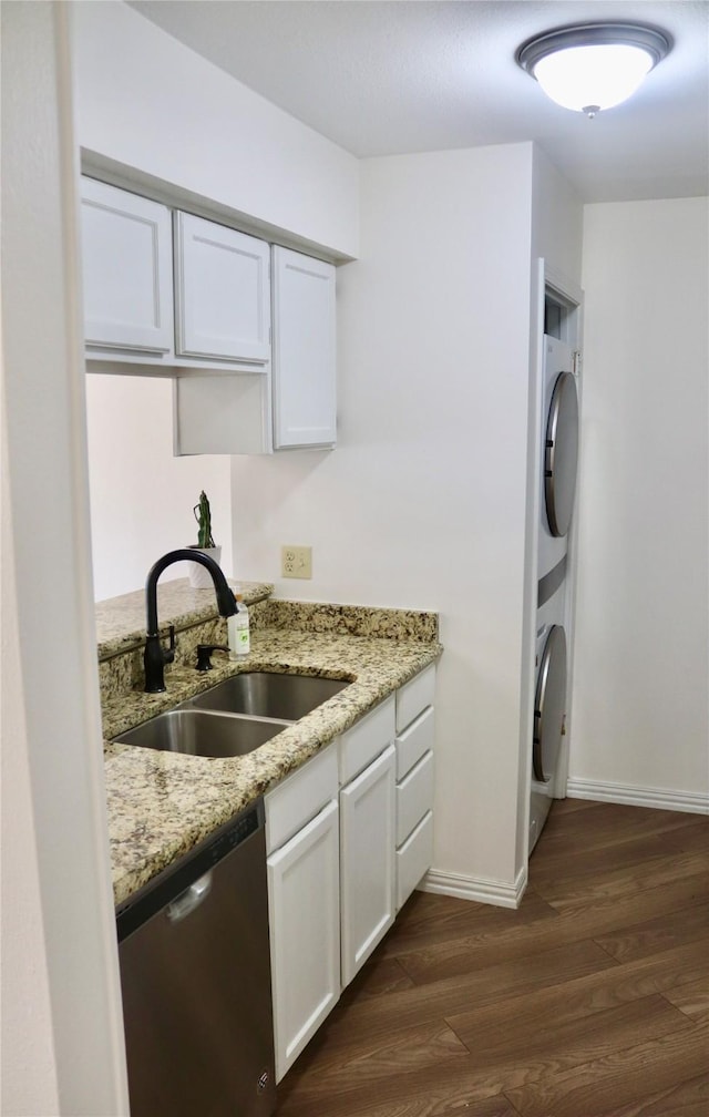 5616 Preston Oaks Rd Unit 508, Dallas, TX 75254 - kitchen featuring stainless steel dishwasher, estacked washer and dryer, a sink, dark wood-style floors, and white cabinets