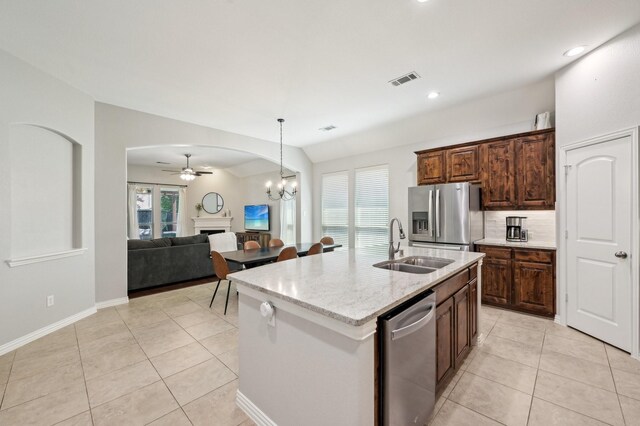 5104 Fringetree Dr, Mckinney, TX 75071 - kitchen with appliances with stainless steel finishes, a sink, a fireplace, ceiling fan, and light tile patterned flooring
