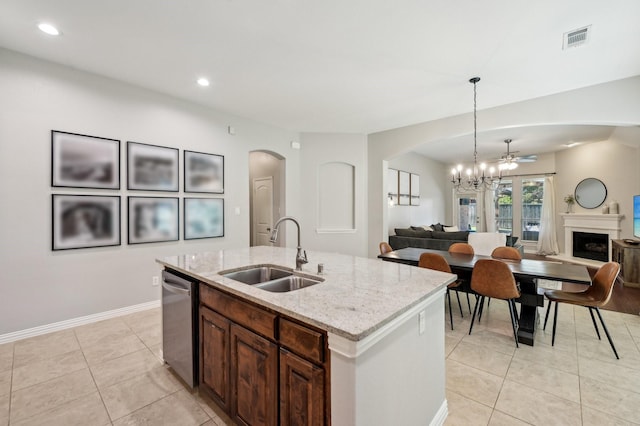 5104 Fringetree Dr, Mckinney, TX 75071 - kitchen featuring a sink, stainless steel dishwasher, arched walkways, open floor plan, and light tile patterned floors