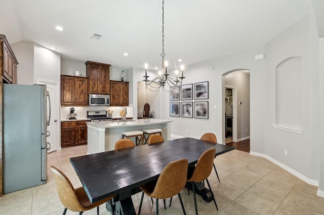 5104 Fringetree Dr, Mckinney, TX 75071 - dining area featuring arched walkways, light tile patterned floors, a chandelier, recessed lighting, and baseboards