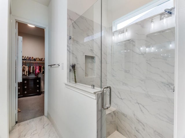 6656 Windfall Dr, Fort Worth, TX 76135 - bathroom featuring marble finish flooring, a marble finish shower, a walk in closet, and baseboards