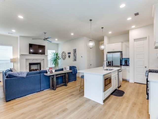 6656 Windfall Dr, Fort Worth, TX 76135 - kitchen with stainless steel appliances, open floor plan, light wood finished floors, a kitchen bar, and recessed lighting