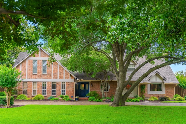 7110 Mossvine Dr, Dallas, TX 75254 - tudor house featuring a front yard, brick siding, and a shingled roof