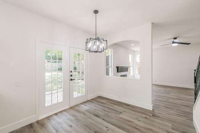 7205 Coventry Cir, North Richland Hills, TX 76182 - unfurnished dining area featuring wood finished floors, french doors, baseboards, a chandelier, and arched walkways