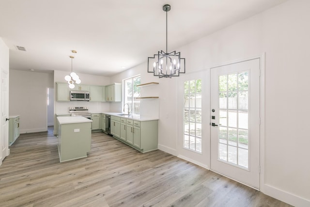 7205 Coventry Cir, North Richland Hills, TX 76182 - kitchen with stainless steel appliances, green cabinetry, a chandelier, a center island, and healthy amount of natural light